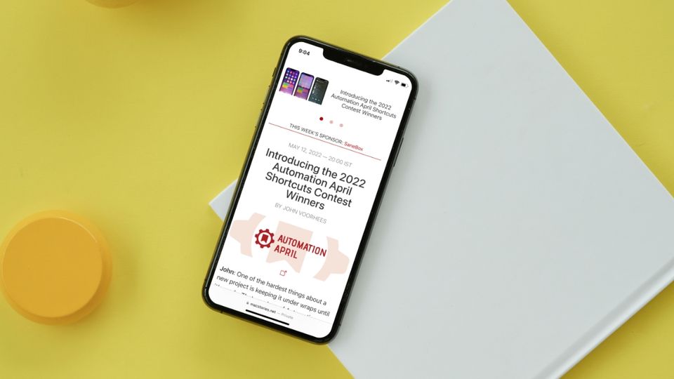 iPhone on top of paper book showing Macstories webpage