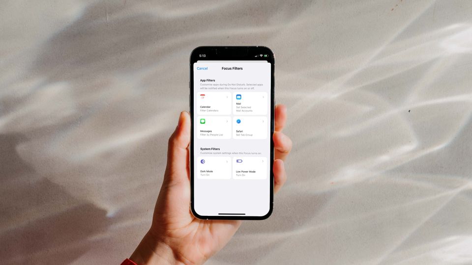 Hand holding iPhone 13 Pro showing Focus Filters to Turn on Low Power Mode on iPhone