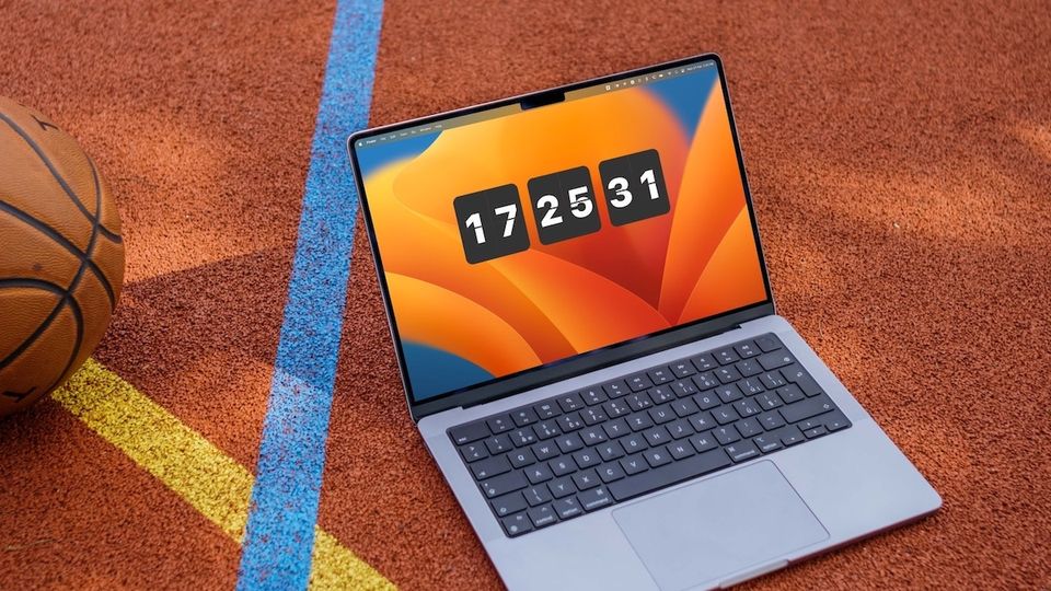 MacBook Pro on basketball court showing a clock on Mac desktop