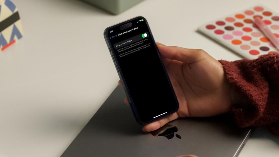 Man holding iPhone in Hand showing Silence Unknown Callers feature